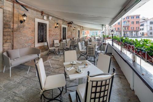 a restaurant with tables and chairs on a balcony at BW Premier Collection CHC Continental in Venice