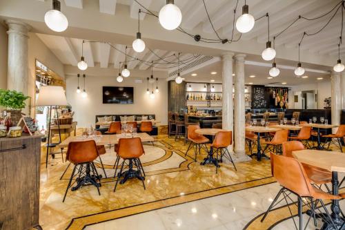 a restaurant with tables and chairs and a bar at BW Premier Collection CHC Continental in Venice
