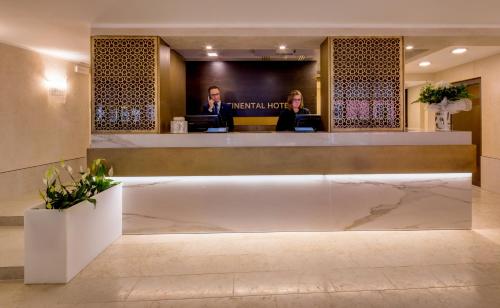 two people at a reception desk in a hotel lobby at BW Premier Collection CHC Continental in Venice