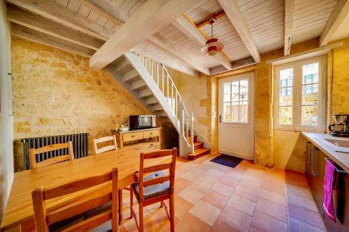 une cuisine avec une table en bois et un escalier dans l'établissement Logis Loiseau avec terrasse, à Saint-Émilion