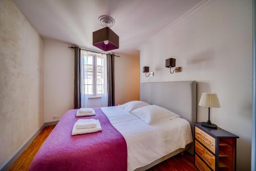 サン・テミリオンにあるLogis Loiseau avec terrasseのベッドルーム1室(大型ベッド1台、タオル2枚付)