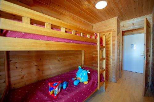 a bedroom with bunk beds with an elephant toy on the bed at Goélia - Les Chalets des Marmottes in Saint-Jean-dʼArves