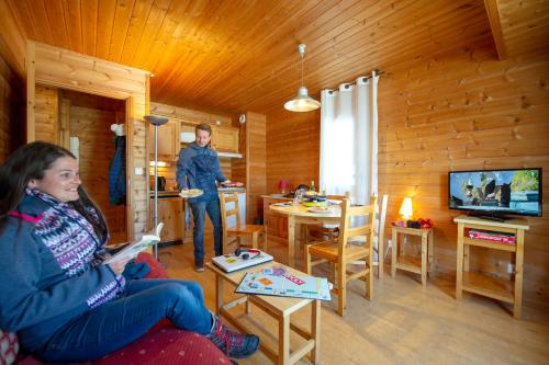 a woman standing in a living room with a girl at Goélia - Les Chalets des Marmottes in Saint-Jean-dʼArves