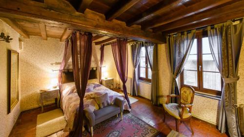 1 dormitorio con cama con dosel y ventanas en Les Lavandières de Fontaine, en Fontaine-lès-Vervins