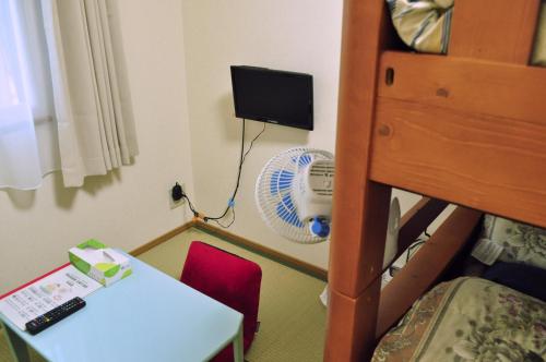 a room with a desk and a bed and a table at Guest house HiDE in Lake Toya