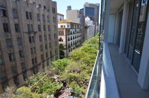 a balcony of a building with trees and buildings at Taj Luxury Suite in Cape Town