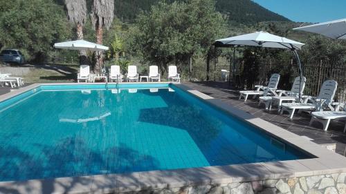 a large swimming pool with chairs and umbrellas at Casa Siciliana Altarbiah in Trabia