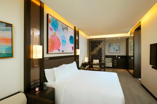 a bedroom with a large white bed and a television at Banyan Tree Kuala Lumpur in Kuala Lumpur