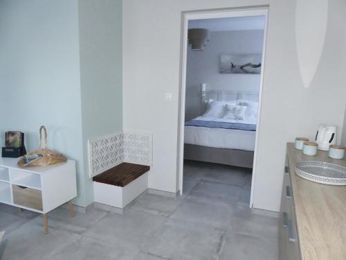 a white bedroom with a bed and a mirror at Les Ambaciales in Amboise