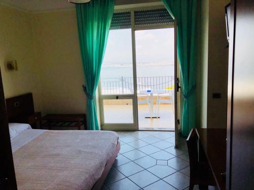 a bedroom with a bed and a view of the ocean at Hotel Elisabetta in Castellammare di Stabia