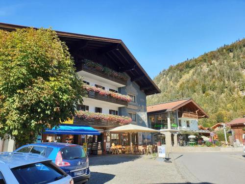 a building with cars parked in front of it at Hotel Löwen in Reit im Winkl