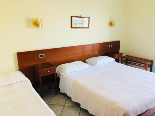 a hotel room with two beds with white sheets at Hotel Elisabetta in Castellammare di Stabia