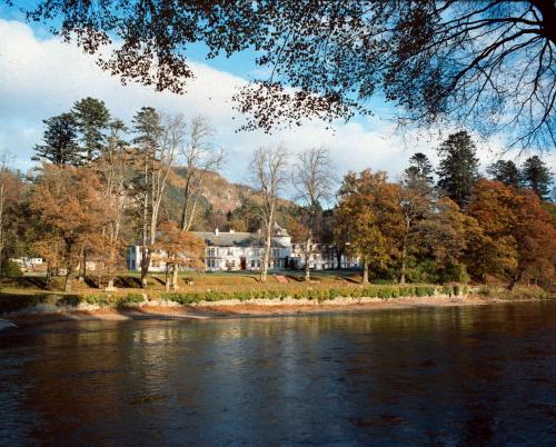 a large house on the shore of a river at Dunkeld House Hotel in Dunkeld