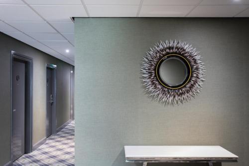 a mirror on a wall in a hallway with a table at Dunkeld House Hotel in Dunkeld