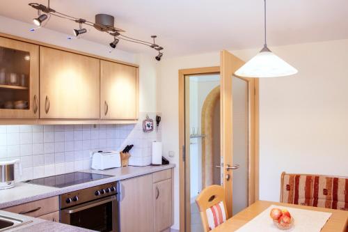 a kitchen with wooden cabinets and a table with fruit on it at Ferienwohnungen Tweraser in Bad Birnbach
