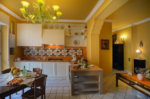 uma cozinha com paredes amarelas e uma mesa e cadeiras em Donna Filomena Casa Vacanza di Charme em Salerno