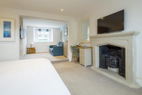 a living room with a fireplace with a tv above it at Rashleigh Arms in St Austell