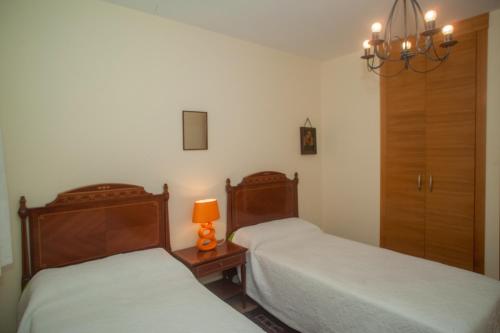 a bedroom with two beds and a lamp on a table at Beatiful holiday flat in Galicia with sea views and next to the "Camino de Santiago" in Estorde