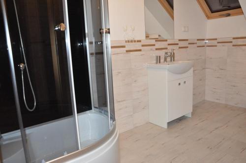 uma casa de banho com um chuveiro e um lavatório. em Zespół Dworsko-Parkowy em Nieżywięć