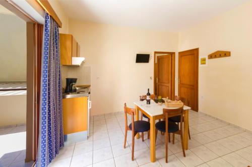 a kitchen and dining room with a table and chairs at Ariadne Beach in Plataniás
