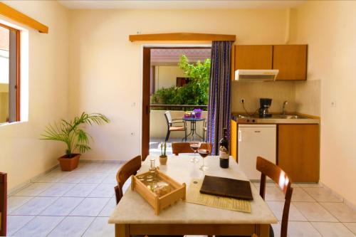 a kitchen and a dining room with a table and chairs at Ariadne Beach in Plataniás