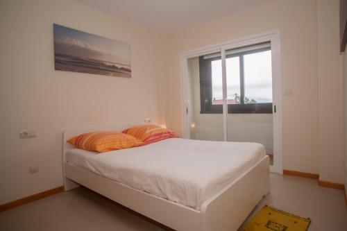 a bedroom with a bed with two pillows and a window at Beatiful holiday flat in Finisterre with sea views and next to the "Camino de Santiago" in Finisterre