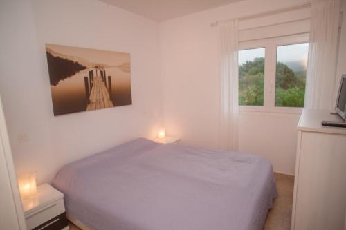 um quarto branco com uma cama e 2 janelas em Beautiful holiday house in Galicia next to the "Camino de Santiago" and next to the beach em Cee