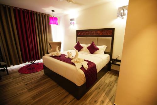 a hotel room with a bed with stuffed animals on it at Hotel Visakka Palani in Palani