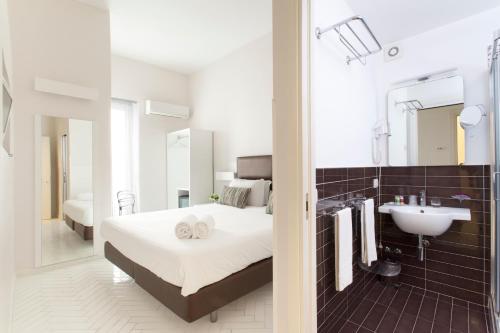 1 dormitorio con cama, lavabo y espejo en New Domus Sorrento, en Sorrento