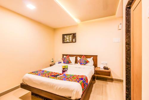 a bedroom with a large bed with colorful pillows at FabExpress Silver Lake - Nr BKC in Mumbai