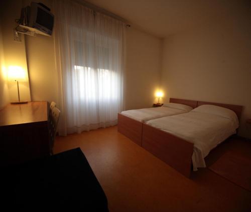 a bedroom with a large bed and a window at ARCOBALENO AFFITTACAMERE in Verona