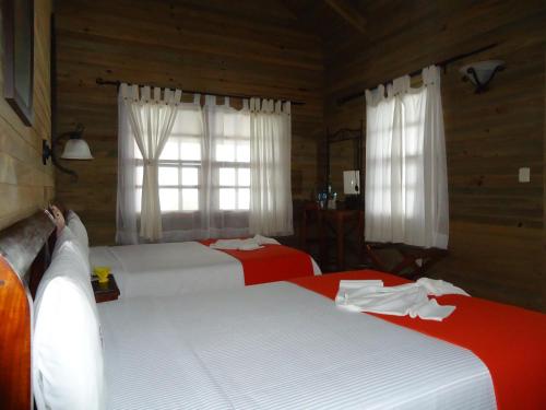 a bedroom with two beds and a window at Finca Hamburgo La Ruta del Cafe in Tapachula