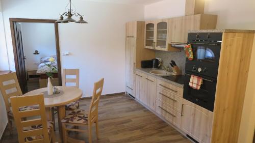a kitchen with a table and a black stove top oven at Club Rezidence Pod Lučí in Loučovice