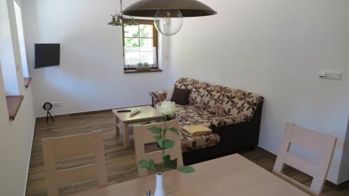 a living room with a couch and a table at Club Rezidence Pod Lučí in Loučovice