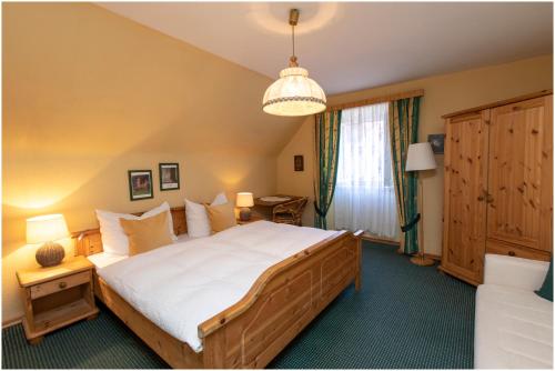 a bedroom with a large bed and a chandelier at Gasthof zur Sonne in Übelbach