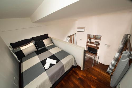um quarto com uma cama com almofadas pretas e brancas em Suite Rodinò em Nápoles