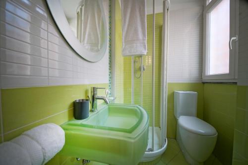 uma casa de banho com um lavatório verde e um WC em Suite Rodinò em Nápoles