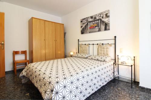 um quarto com uma cama e um armário de madeira em Global Properties, Amplio apartamento muy cerca de la playa em Puerto de Sagunto
