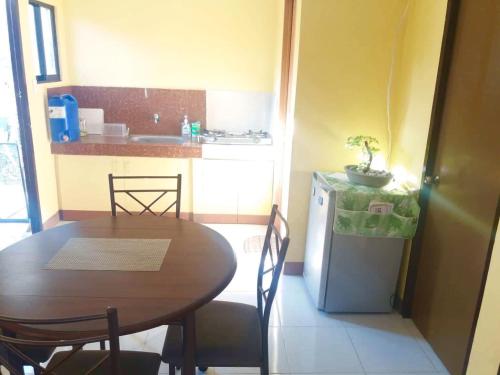 a small kitchen with a table and a small refrigerator at Jireh’s Guests Home in Butuan