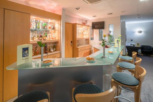 a bar with chairs and a counter in a room at Best Western Hotel im Forum Mülheim in Mülheim an der Ruhr