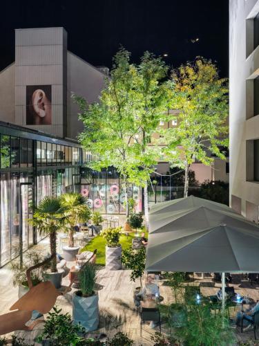 a courtyard with trees and an umbrella in front of a building at STAGE 12 Hotel by Penz in Innsbruck