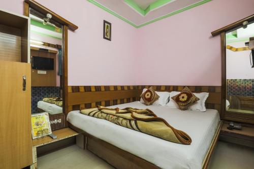 ein Schlafzimmer mit einem großen Bett und einem Spiegel in der Unterkunft Hotel Sweet Home DX in Neu-Delhi