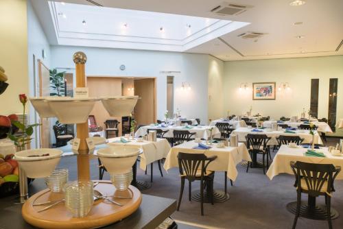 a dining room with white tables and chairs at Best Western Hotel im Forum Mülheim in Mülheim an der Ruhr