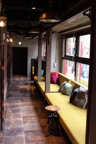 a row of benches in a room with pillows at HARE-TABI SAUNA & INN Yokohama - ハレタビ - in Yokohama