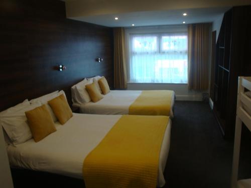 a hotel room with two beds and a window at The Sandhurst Hotel in Blackpool