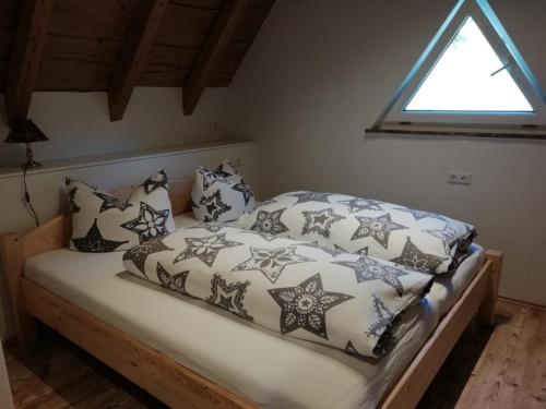 HerrischriedにあるHütteのベッド(白黒の枕付)、窓が備わります。