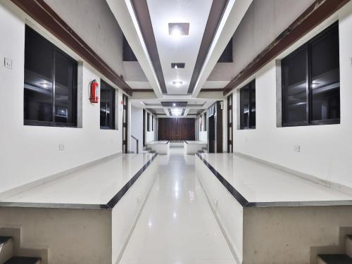 an empty hallway in an office building with windows at Hotel Ambica in Daman