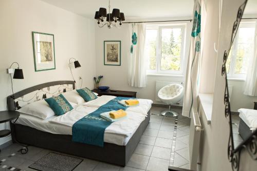 1 dormitorio con cama, ventana y silla en Pivovarský dvůr Zvíkov, en Zvíkovské Podhradí