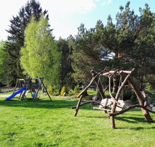 a park with a playground and a swing set at Agroturystyka Pod Pstrągiem in Lipnica