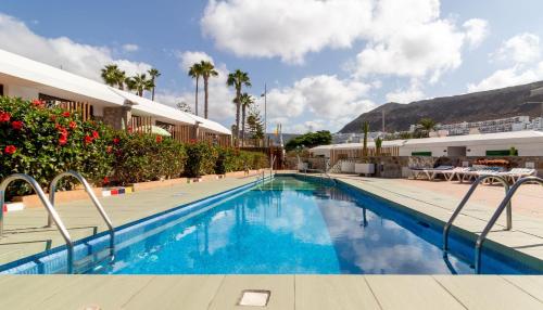 una piscina de agua azul en un complejo en Leticia del Mar Adults Only, en Puerto Rico de Gran Canaria